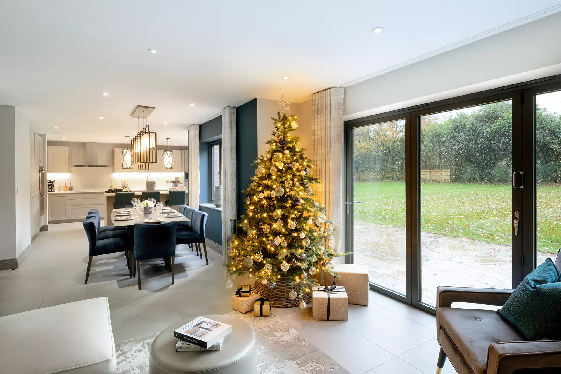 a christmas tree in a room with a dining table and chairs