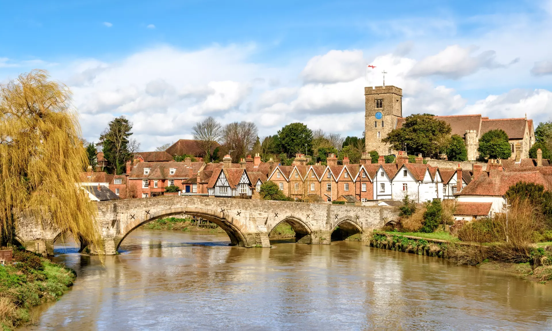 a bridge over a river with a stone bridge and a tower