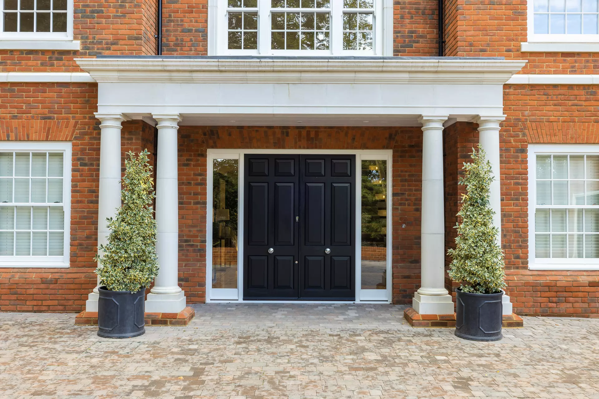 a front door of a building with two trees