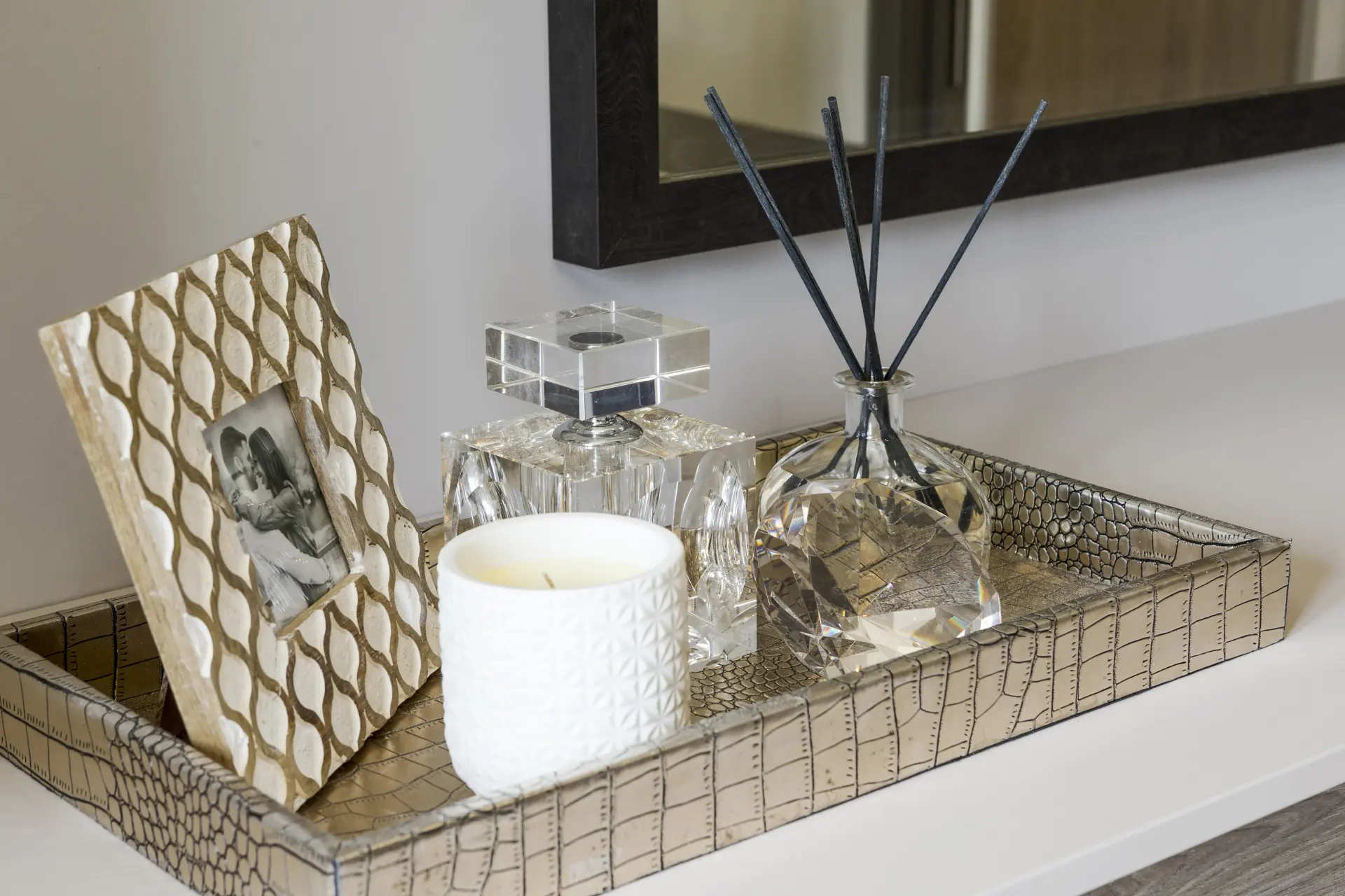 a tray with a candle and a bottle of perfume