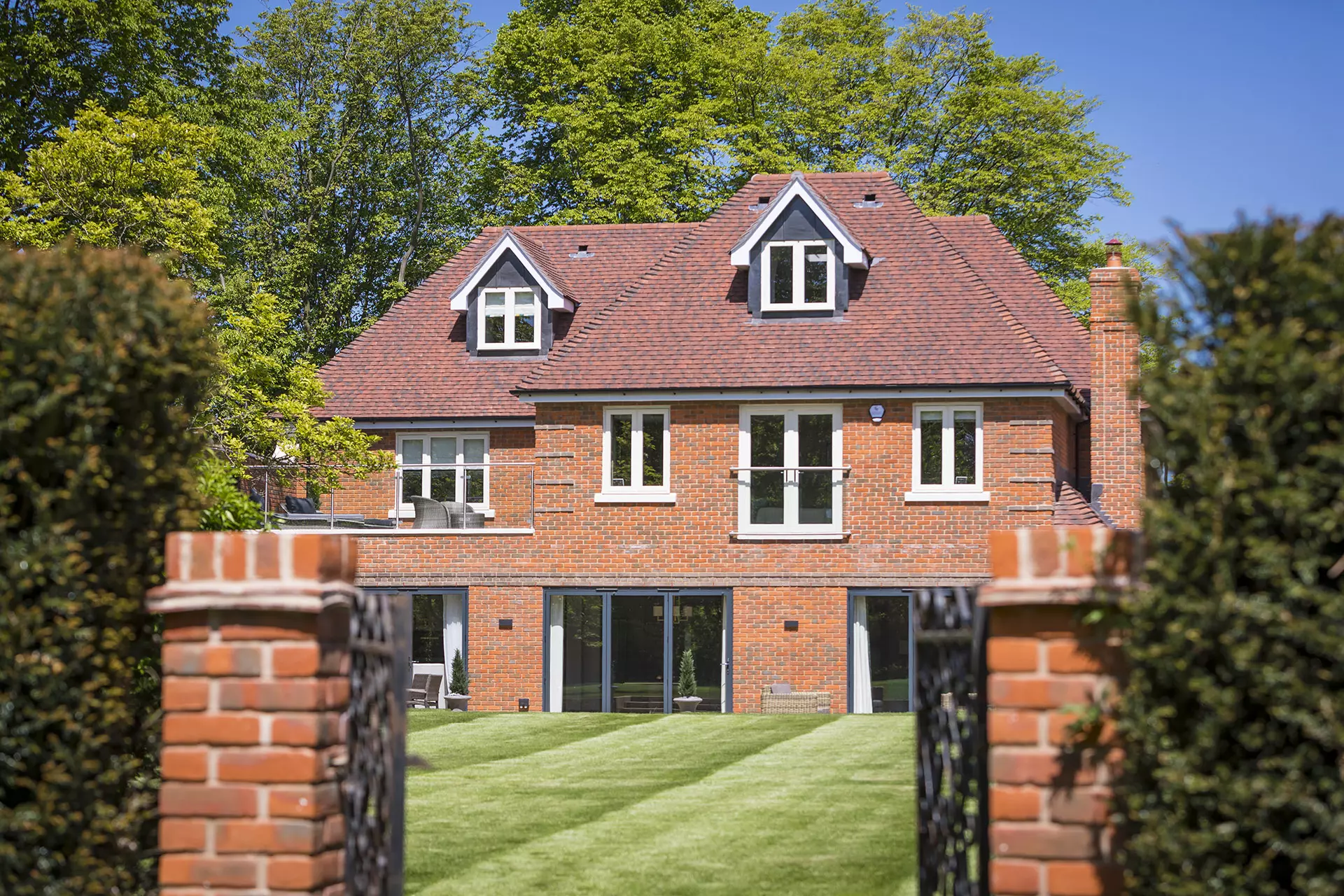 a brick house with a lawn and a fence