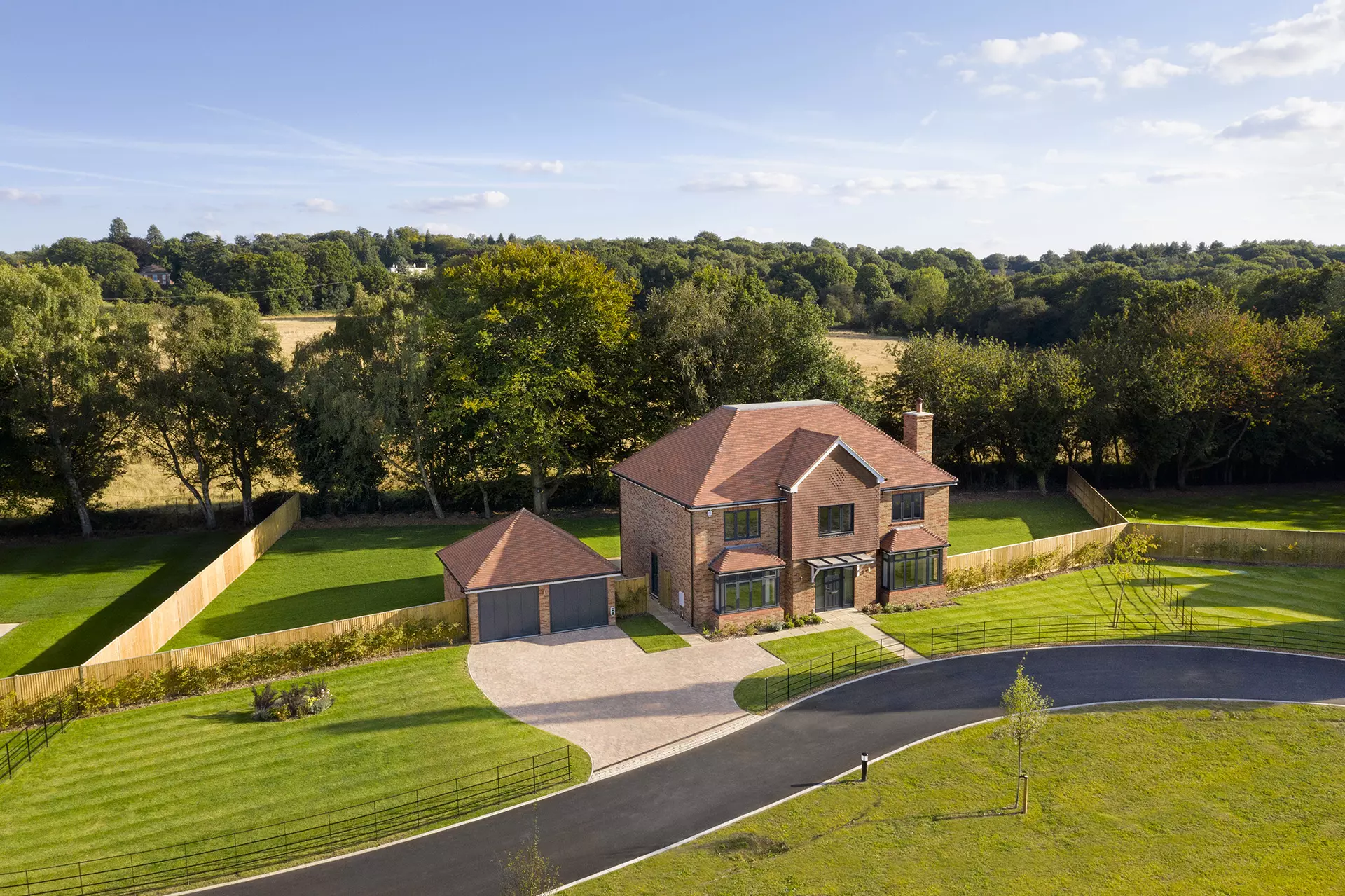 a house with a driveway and trees in the background