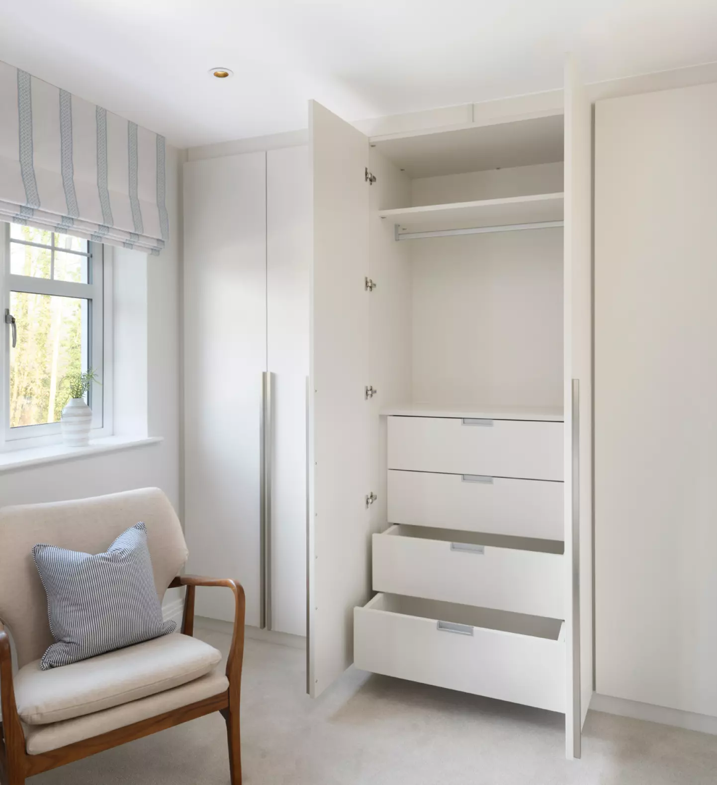 a white room with a chair and a closet