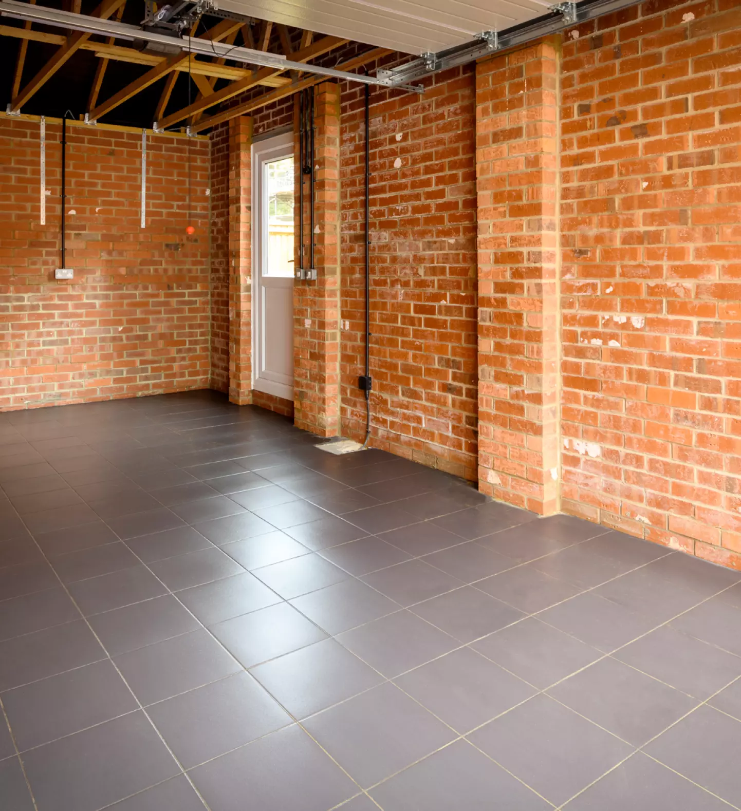 a room with brick walls and a grey tile floor