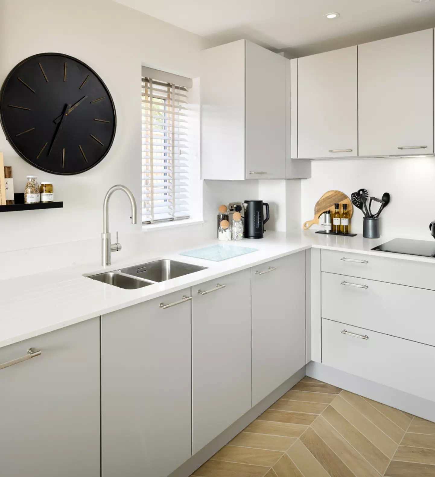a kitchen with white cabinets and a black clock