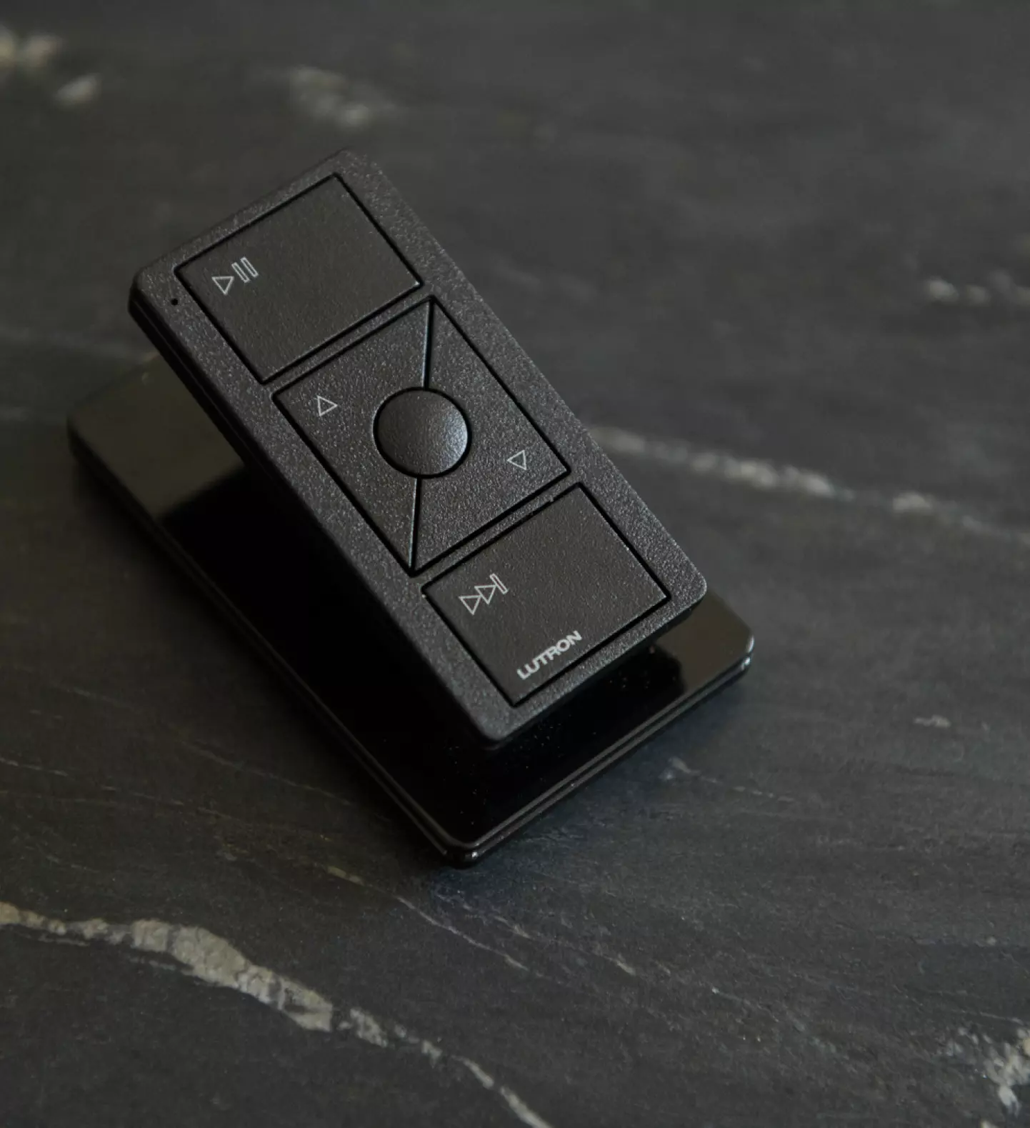 a black remote control on a black surface
