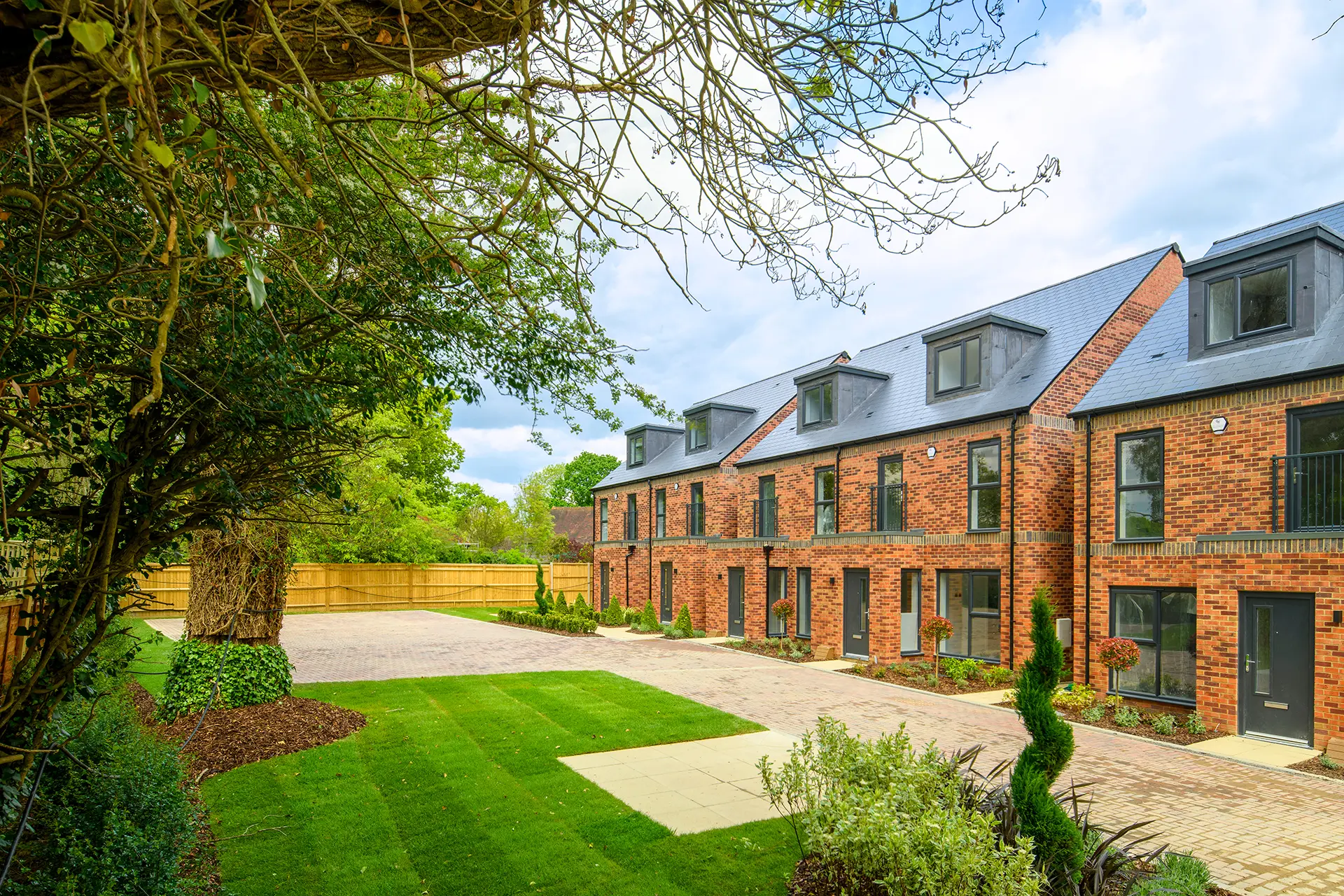 a brick building with a driveway and grass