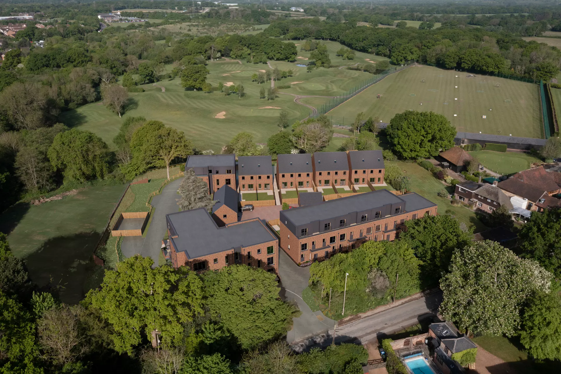 a building with many windows and a lawn with trees