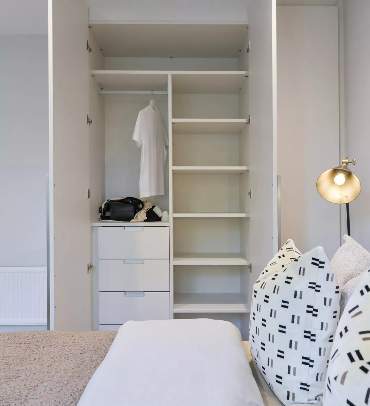 a white bedroom with a bed and a closet