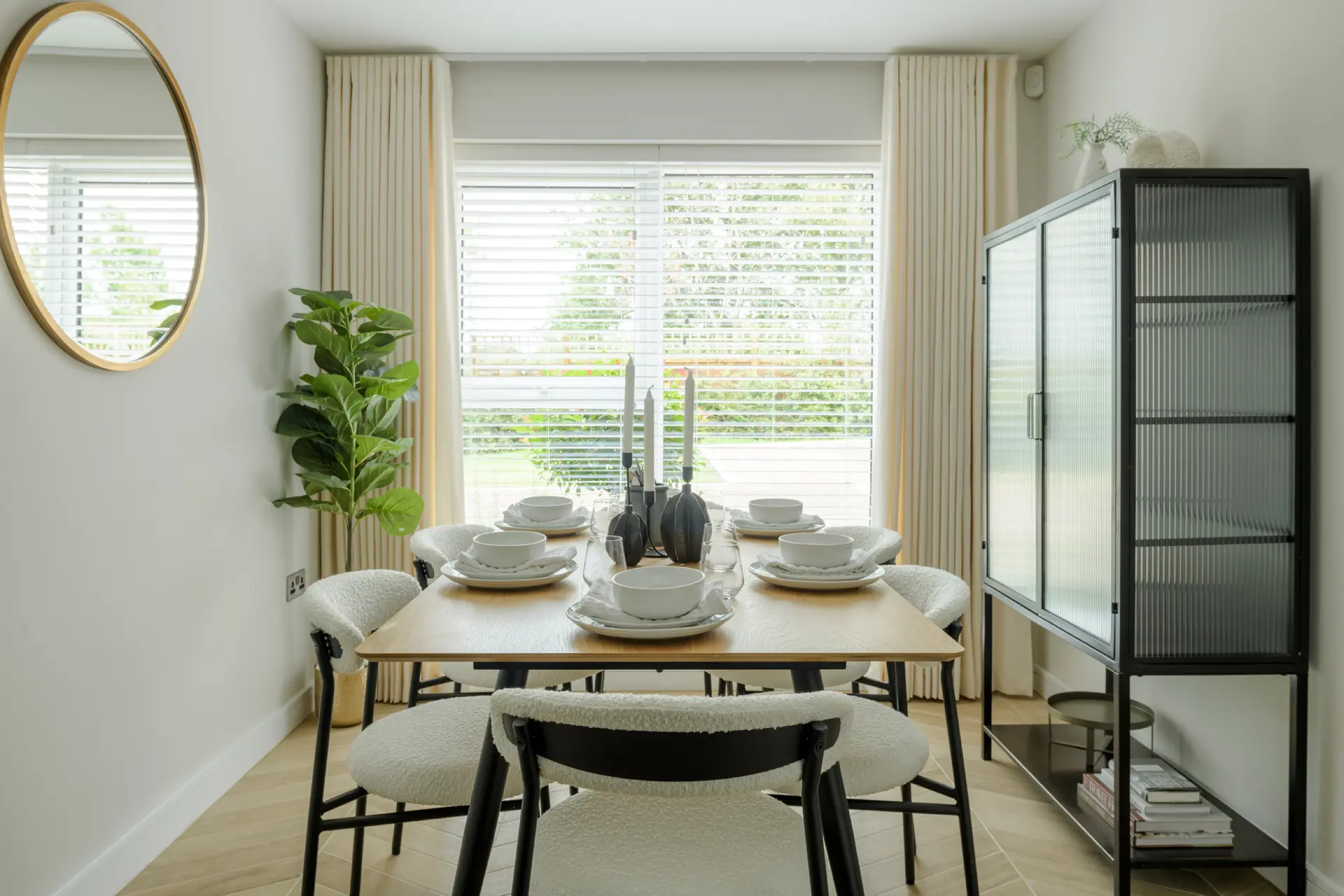 a dining table with white chairs and plates
