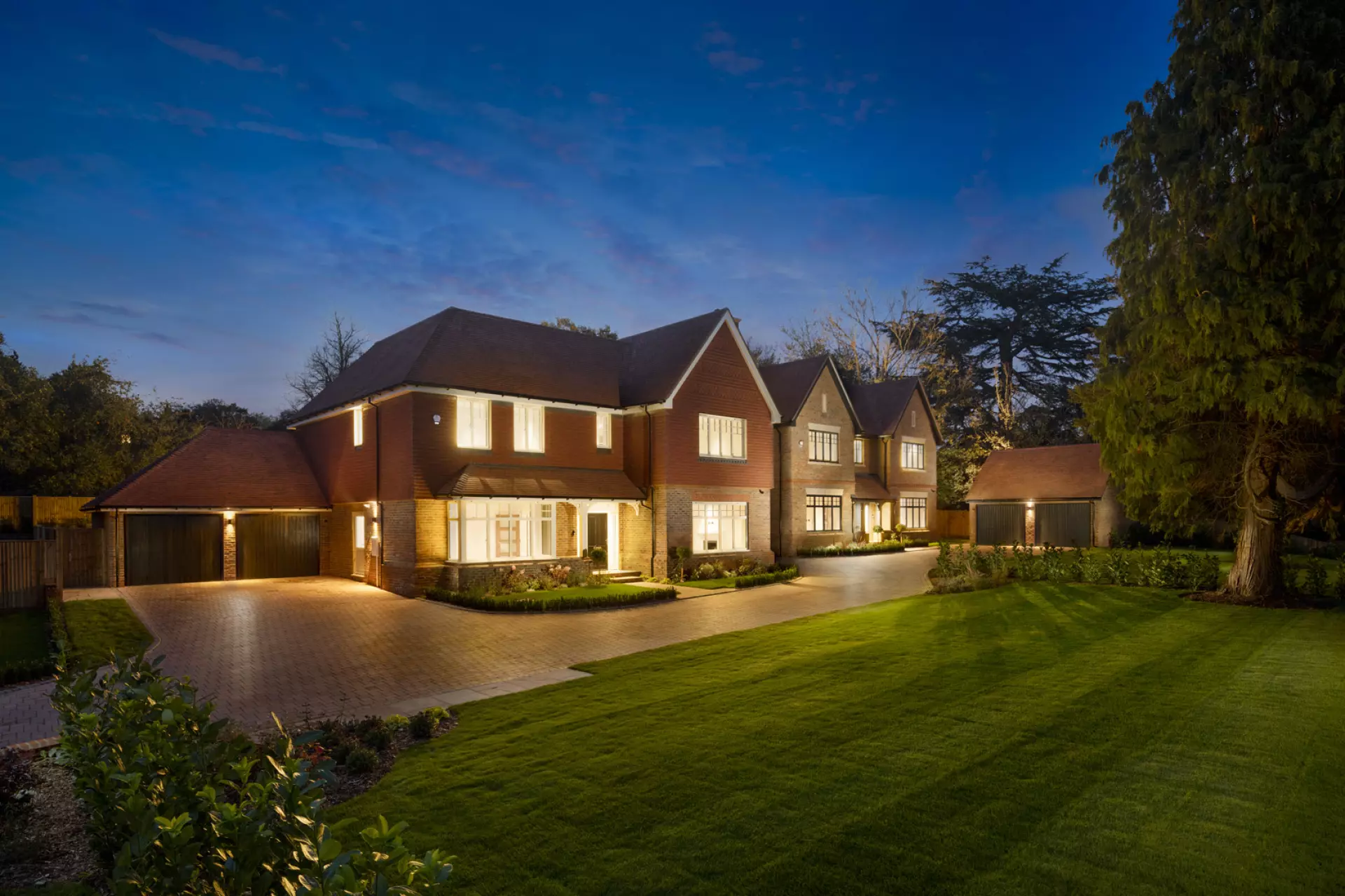 a large brick house with a driveway and lawn