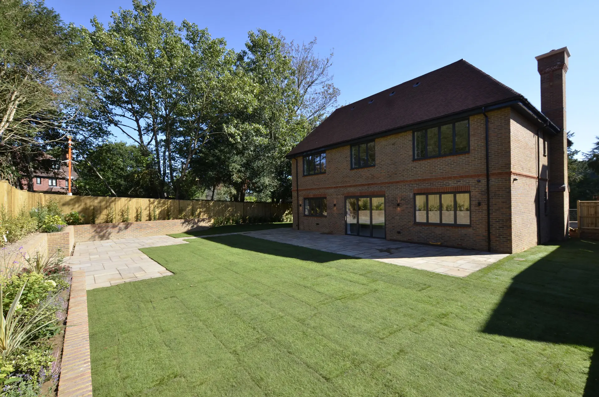a house with a lawn and trees in the background
