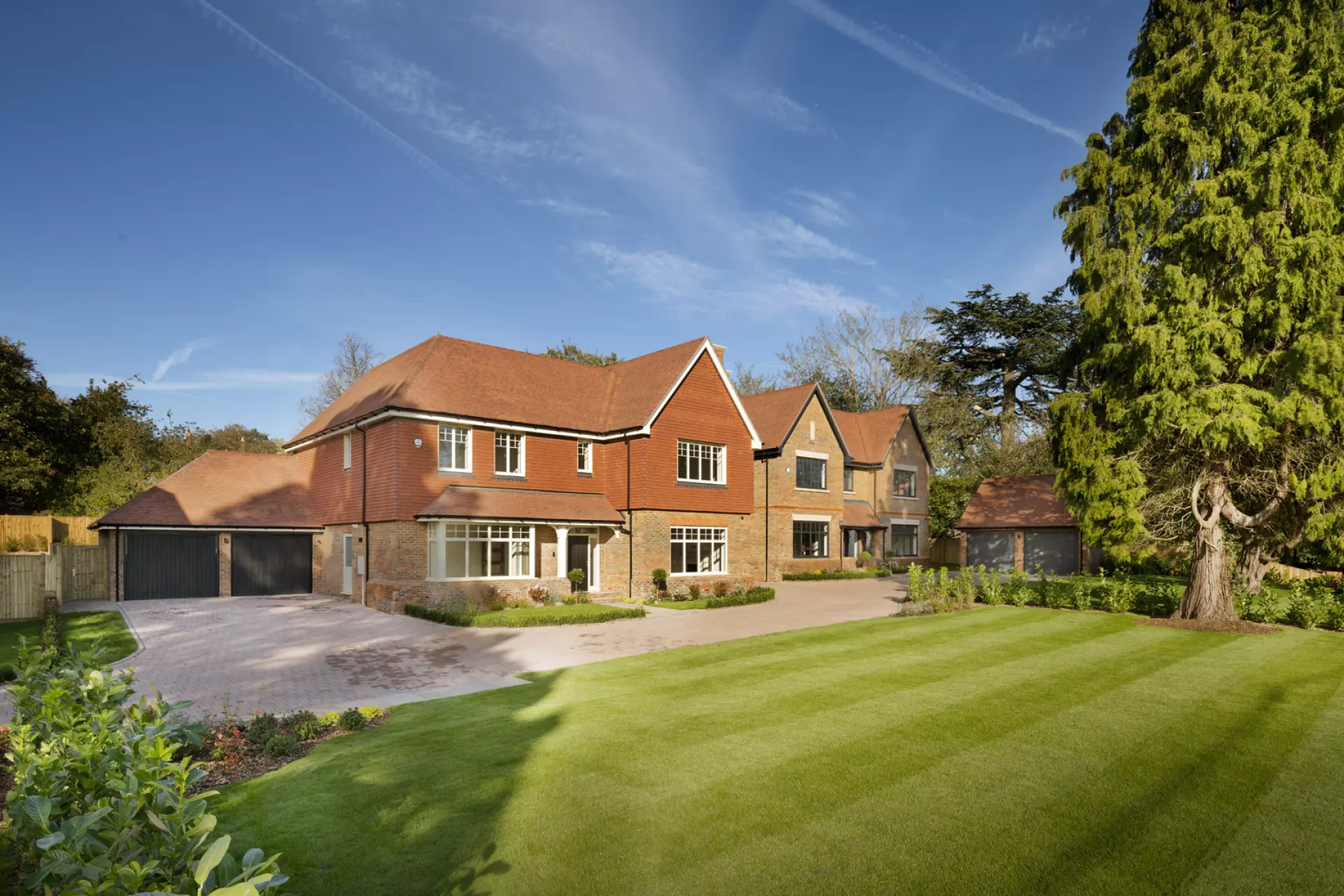 a large brick house with a lawn and a driveway