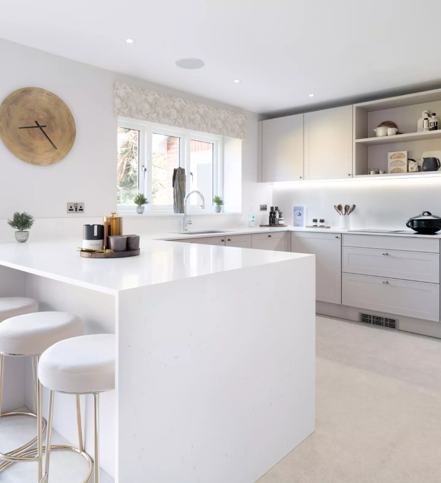 a white kitchen with a white island and white cabinets
