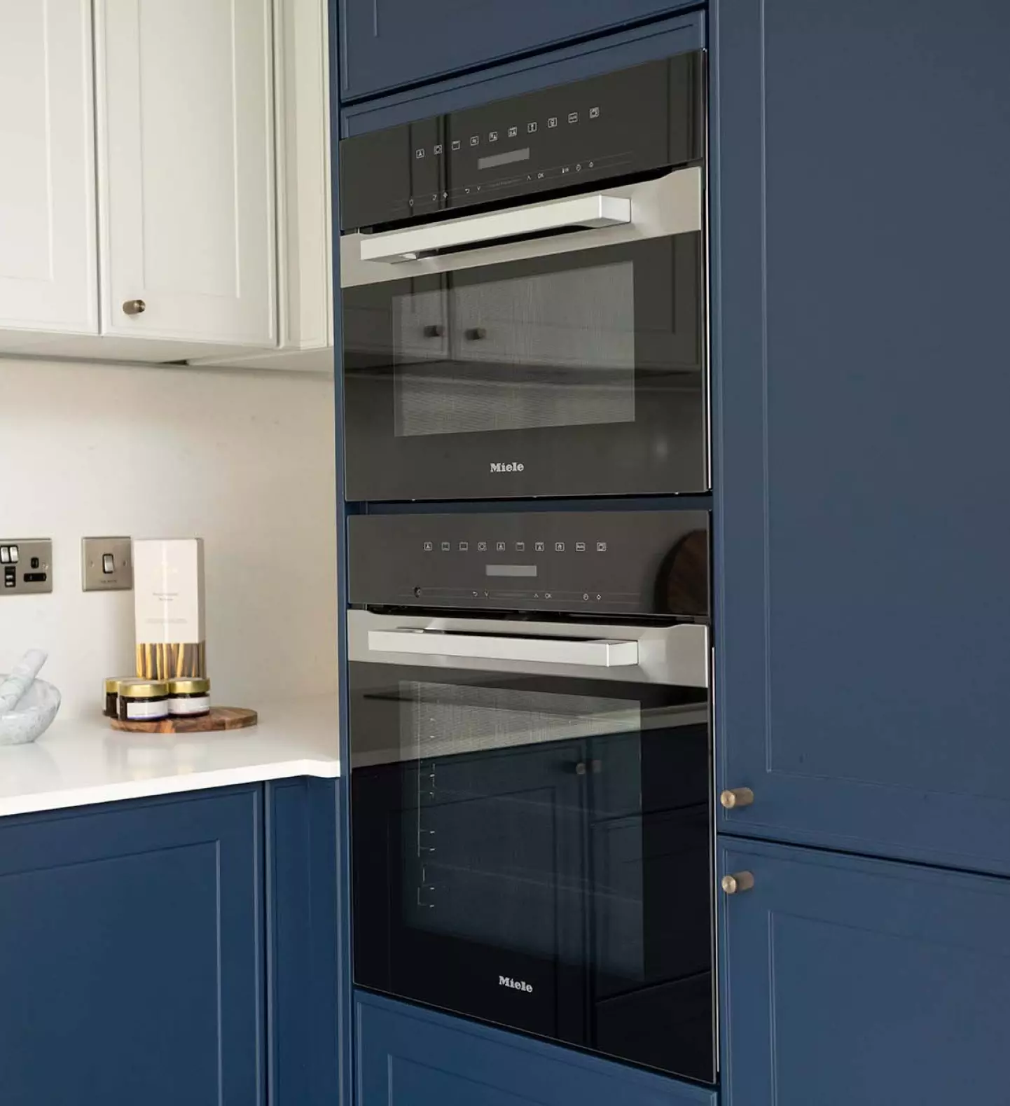 a kitchen with blue cabinets and a microwave oven