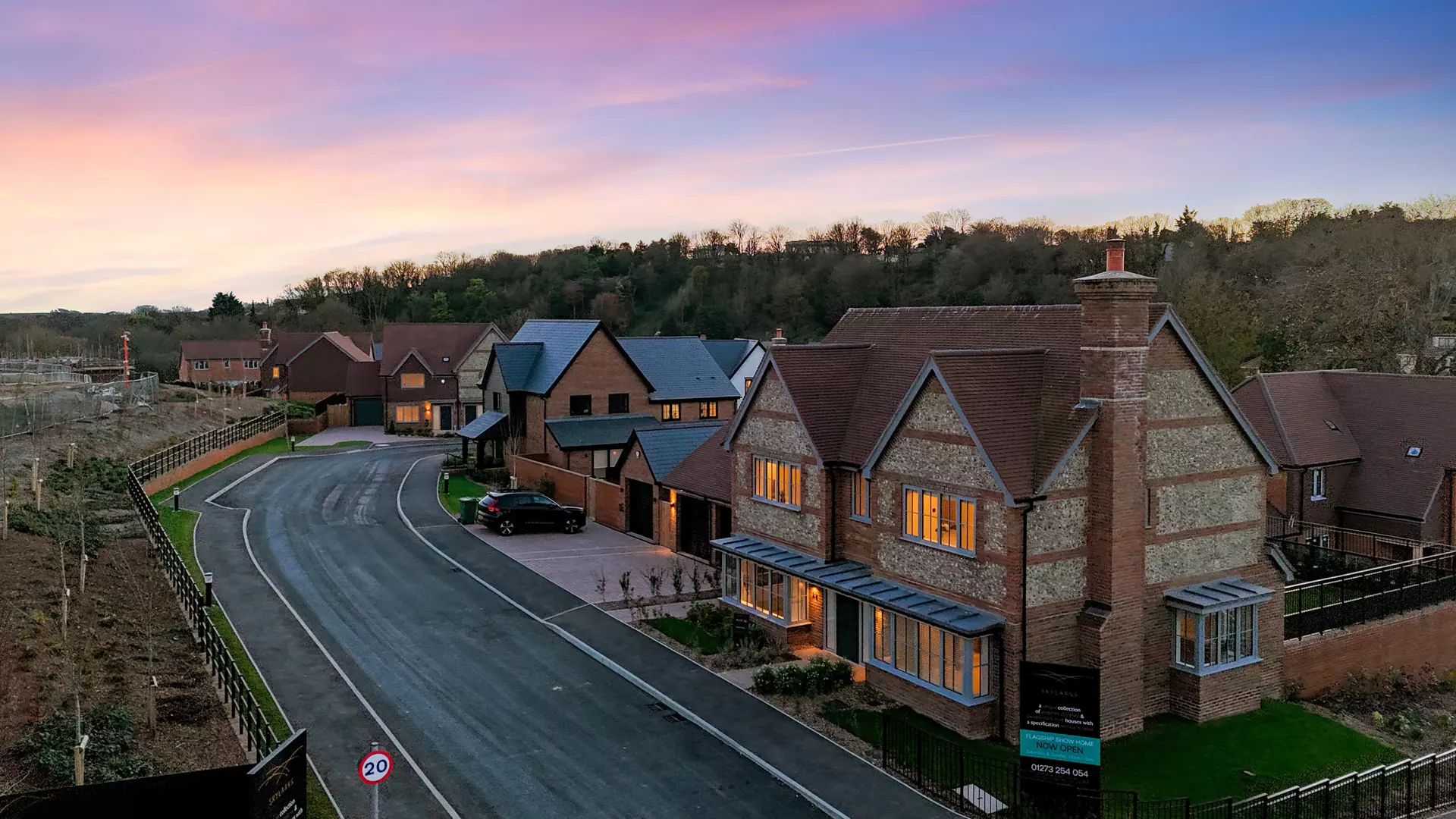 a row of houses with a road and trees in the background