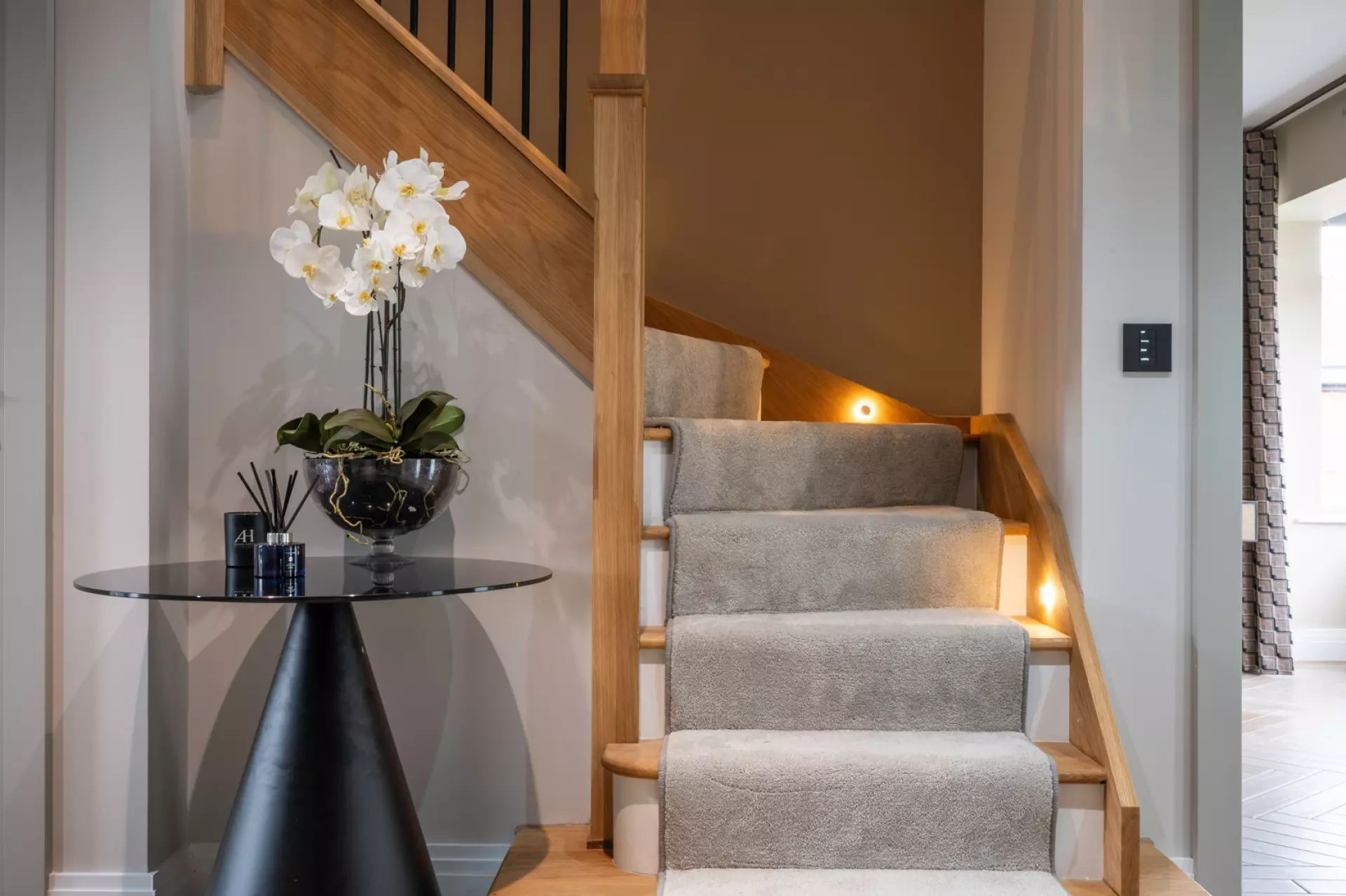 a staircase with a table and a vase of flowers