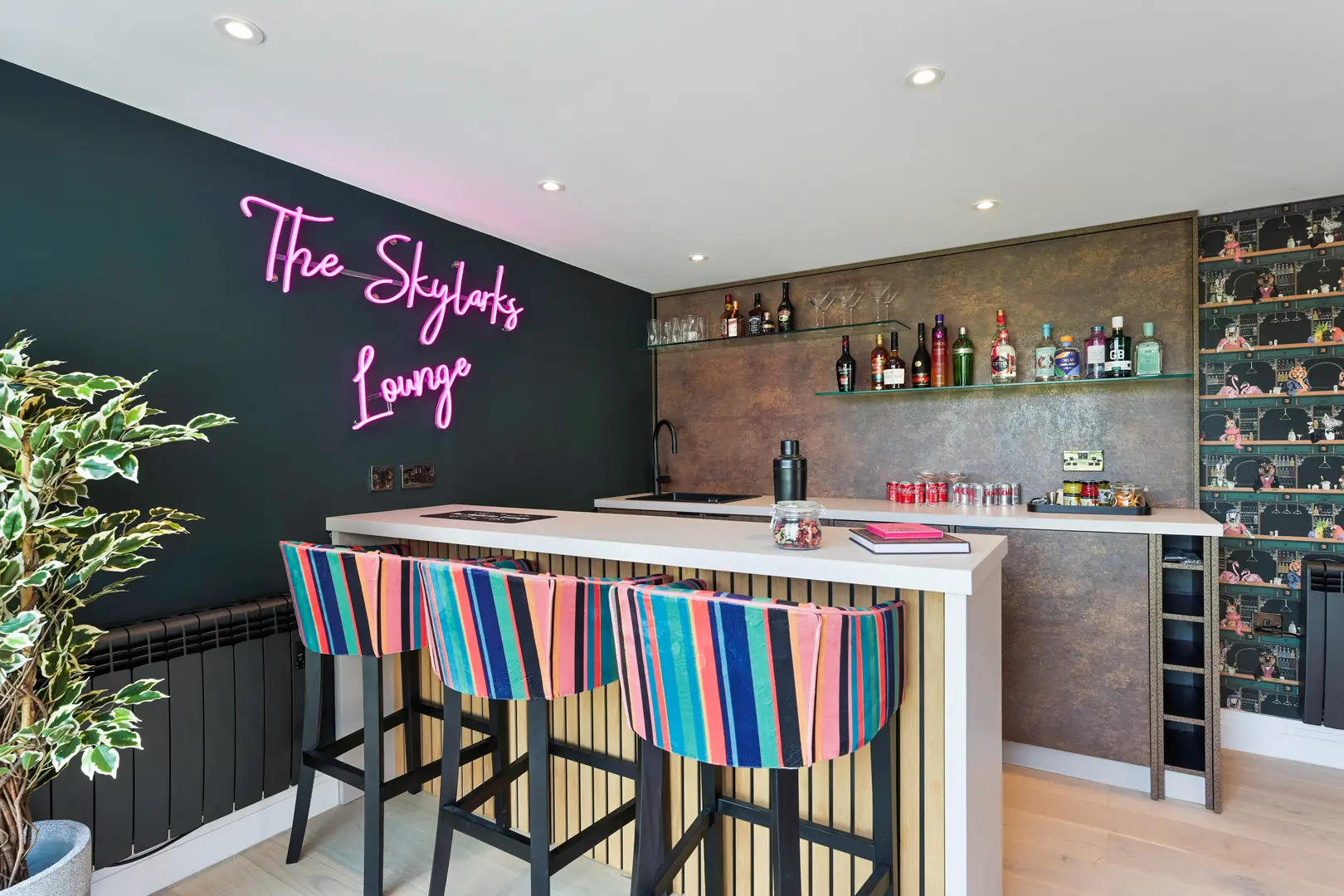 a bar with colorful chairs and a black wall