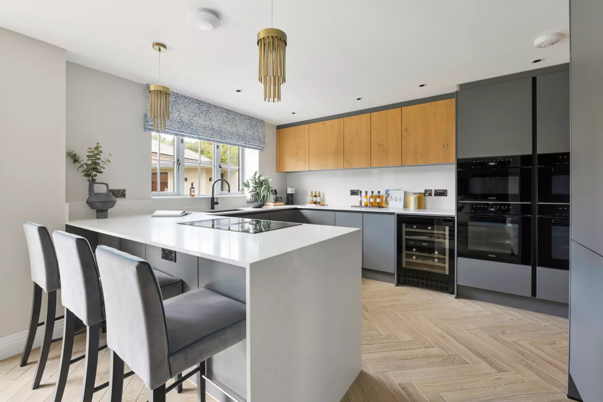 a kitchen with a white island and gray chairs