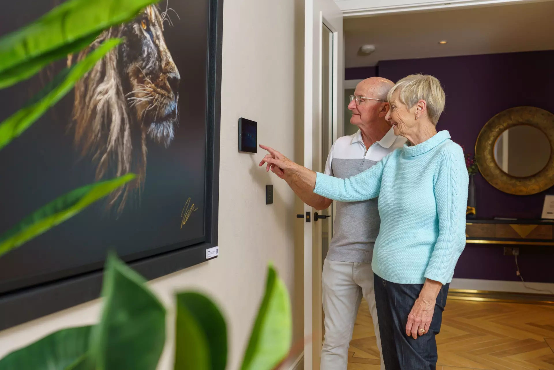 a man and woman looking at a painting on a wall