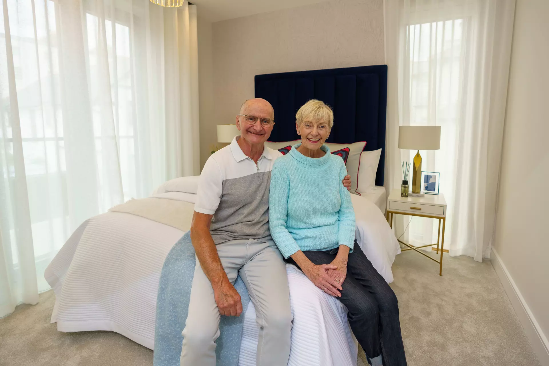 a man and woman sitting on a bed