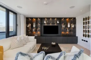 a living room with a tv and shelves