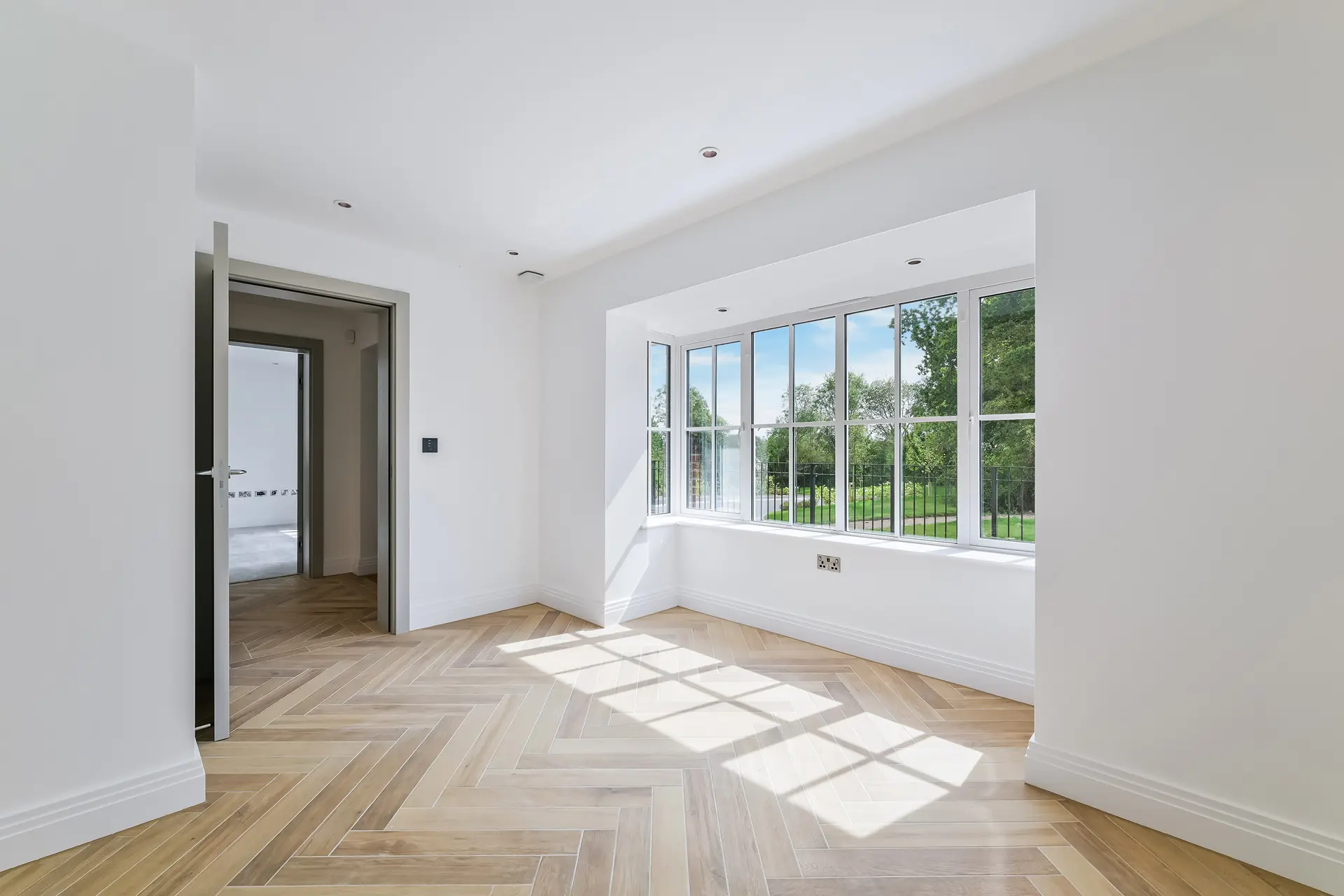 a room with a door open and a wood floor