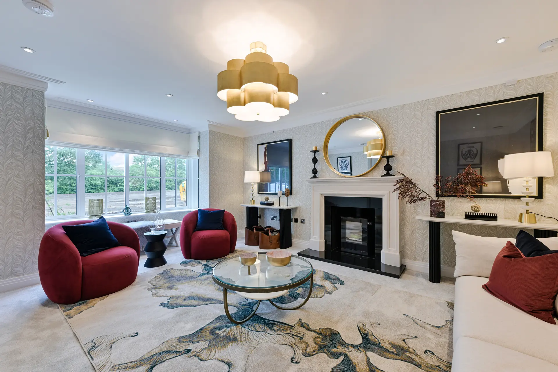 a living room with a fireplace and red chairs